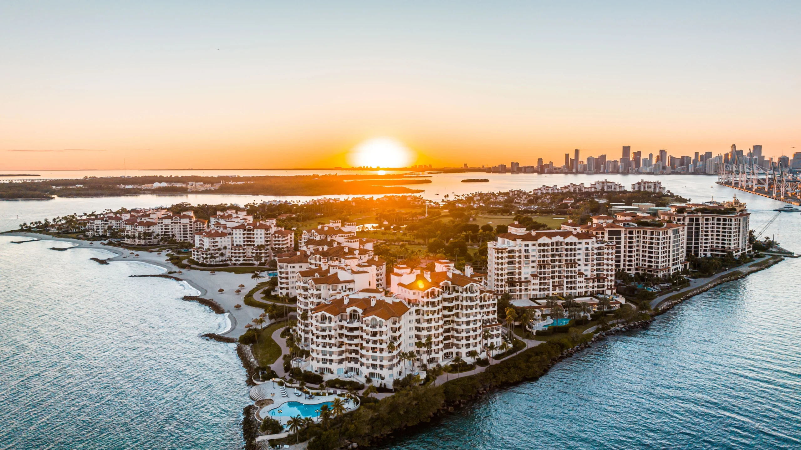 This is a panoramic sunset view of Fisher Island, an exclusive residential community located off the coast of Miami, Florida.